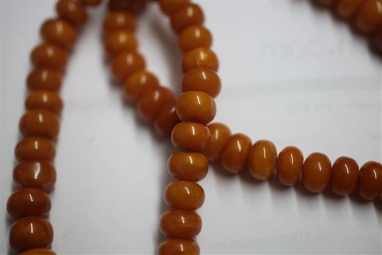 A single strand graduated disc shaped amber bead necklace with rose cut diamond and ruby set amber drop pendant, gross weight